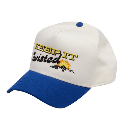Cap is white with a blue brim. Featured on the front in yellow writing is "KEEP IT" directly below in black writing is "Twisted" in script and a small graphic of a mountain and sun.