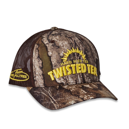 A camouflage trucker hat with brown mesh back panels, featuring yellow embroidered text that reads 'TWISTED TEA' and 'HARD WATERS TEA' with a sun graphic on the front, and 'Team REALTREE' on the side.