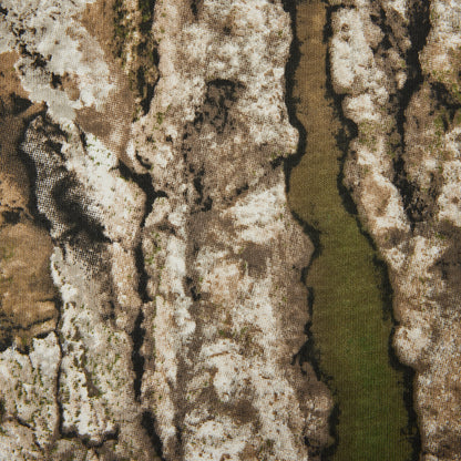 A close-up of a textured fabric pattern featuring a bark-like design in shades of brown, beige, gray, and a vertical olive-green stripe.