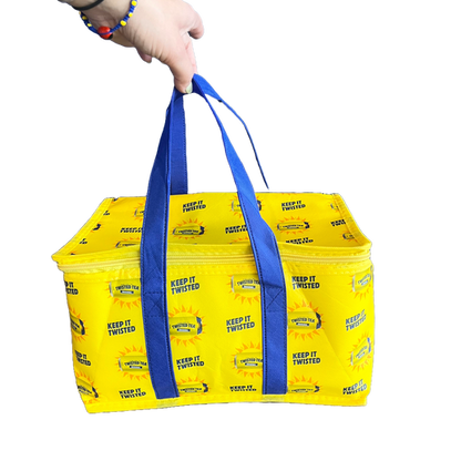 Close-up of yellow soft cooler bag with blue handles. Cooler is covered in writing "Keep it Twisted", and Twisted Tea cans with sun around them.